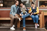 people sitting on a bench with their babies in Colugo baby carriers