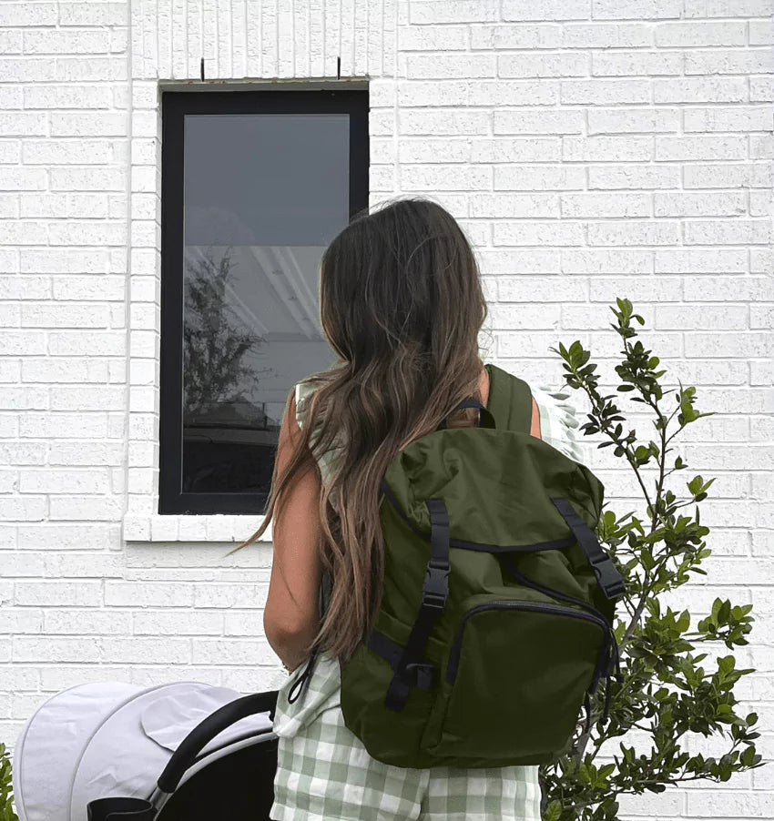 The Parent Backpack, Olive in use by a parent